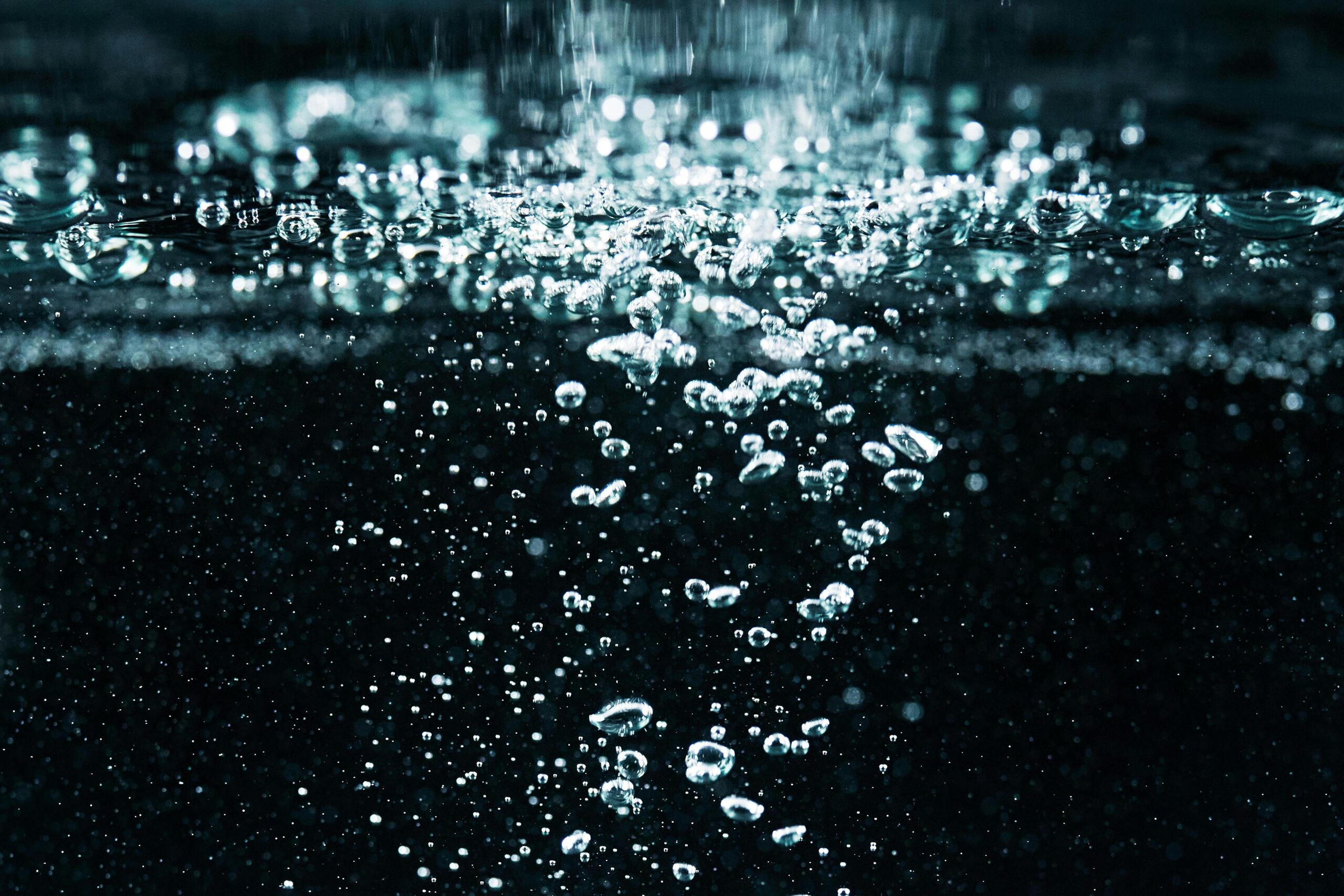 A detailed macro shot of effervescent bubbles rising in water, showcasing fizz and movement.